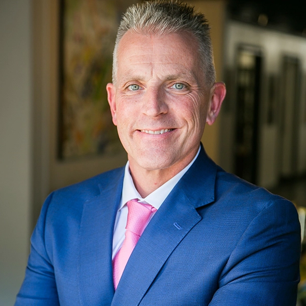 Middle-aged man with a crewcut in a blue jacket and a pink tie